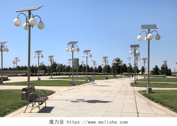 在明亮的天空下公园的小路和太阳能路灯小巷里的公园与太阳能供电的灯笼